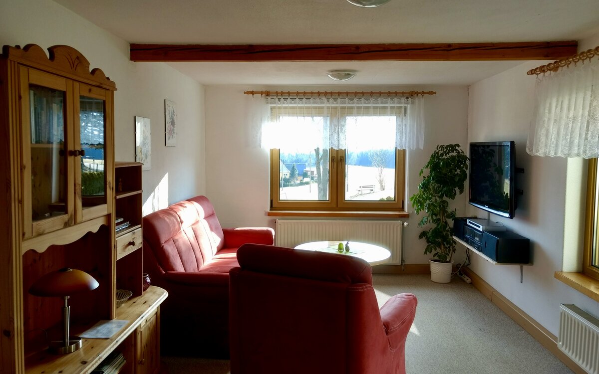 Wohnzimmer mit Sitzgruppe und Blick ins Grüne